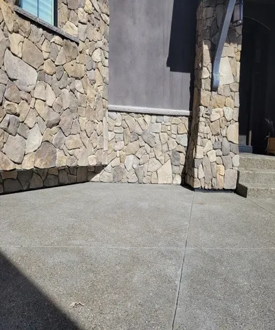 finished deliverable - ground view of natural stone installed to bay window and entry walkway