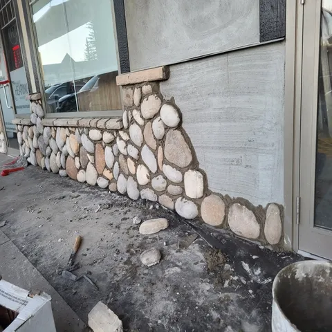 tuckpointing in progress on a Calgary masonry wall, mortar joints being raked and repacked